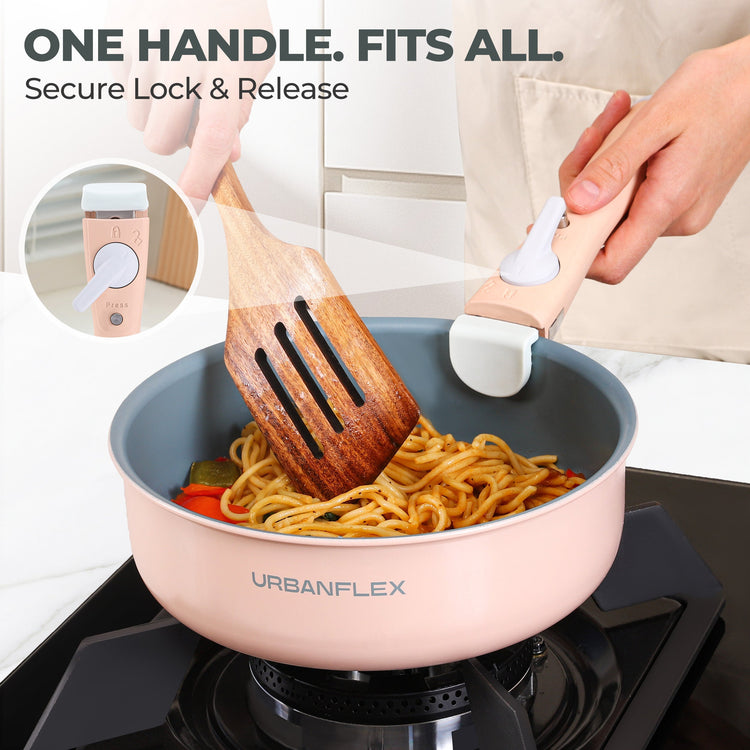 Person cooking noodles in a pink Urbanflex pot with a wooden spatula and white spoon.
