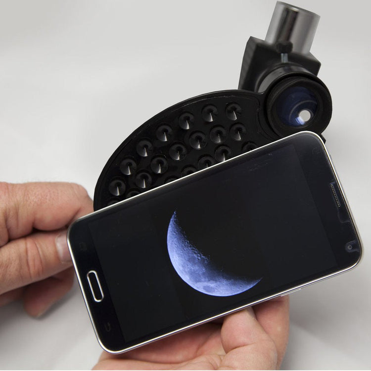 Smartphone with a telescope attachment displaying an image of the moon.