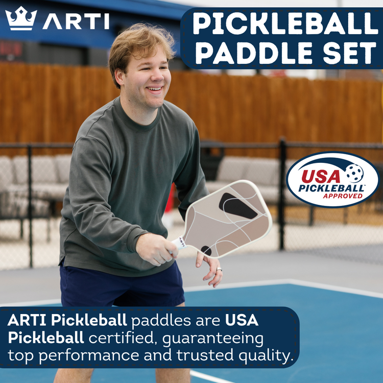 Person holding a pickleball paddle on a court with ARTI branding and USA Pickleball certification.