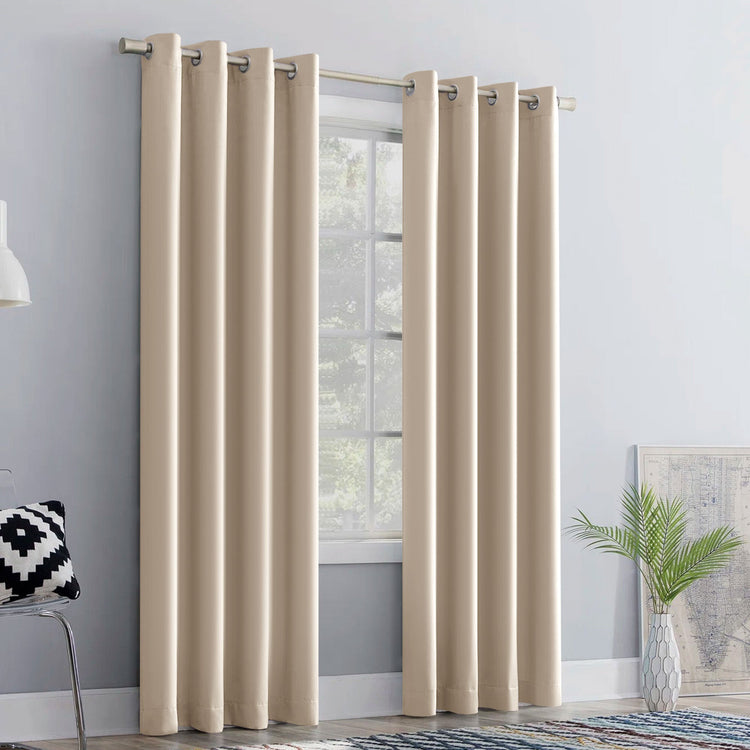 Beige curtains hanging in a room with a window, light gray walls, and decorative elements.