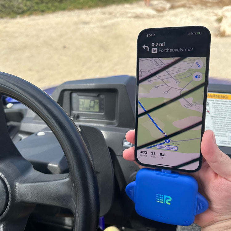 Person holding a phone with GPS app on a car dashboard