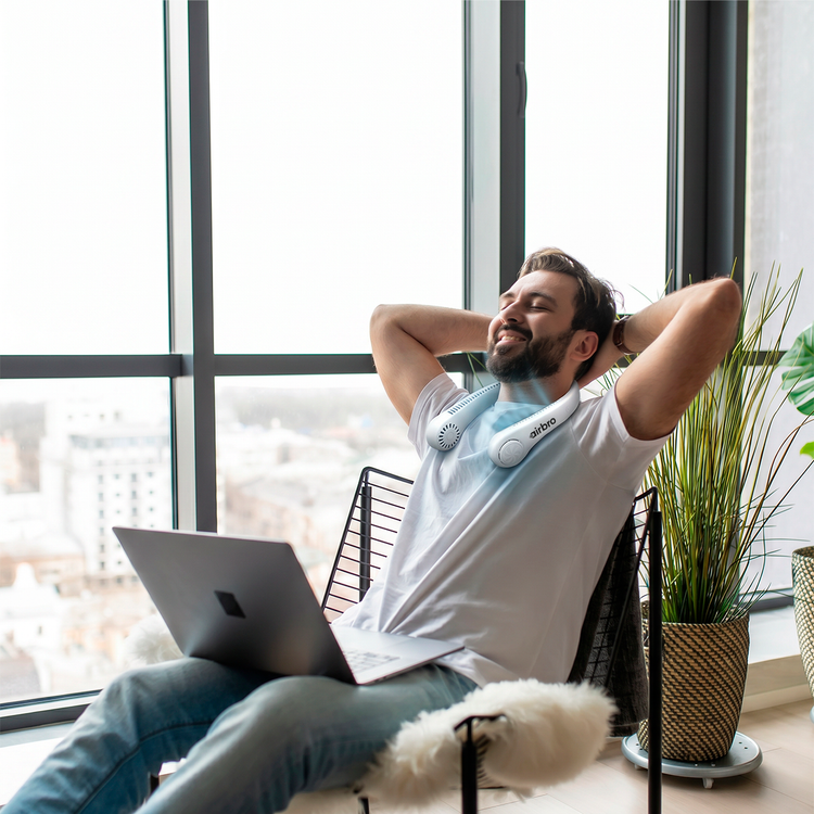 Man relaxing with a laptop on his lap in a modern office setting