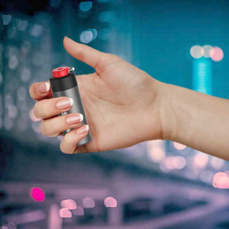 Hand holding a cylindrical object with a red top against a blurred cityscape background