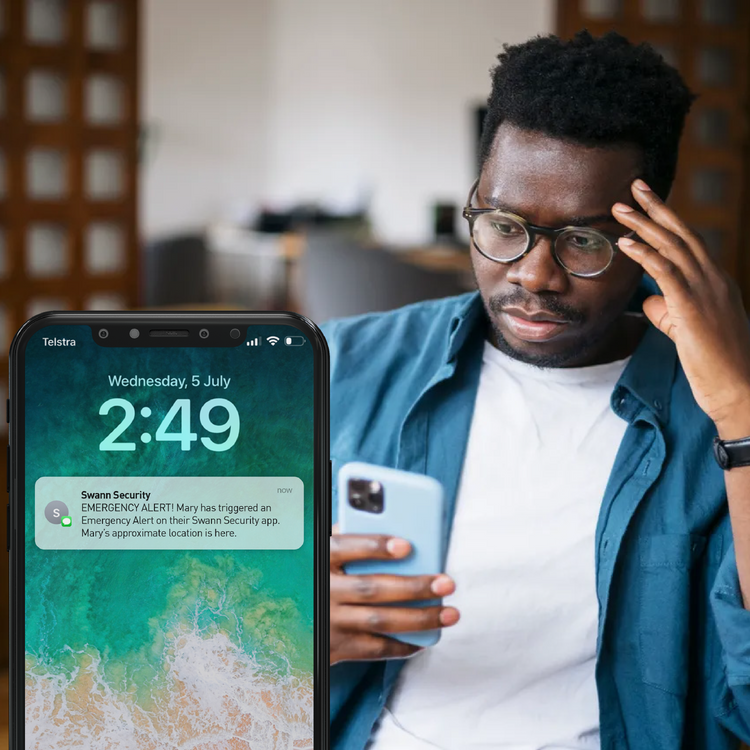 Man holding two smartphones with emergency alerts displayed