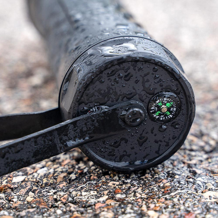Close-up of a black metal object with a compass on a textured surface