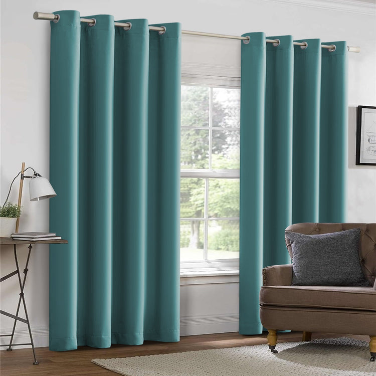 Teal curtains in a room with a couch and window