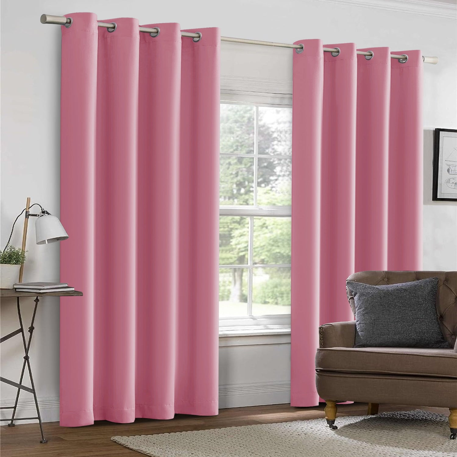 Pink curtains hanging in a room with a window and a sofa.