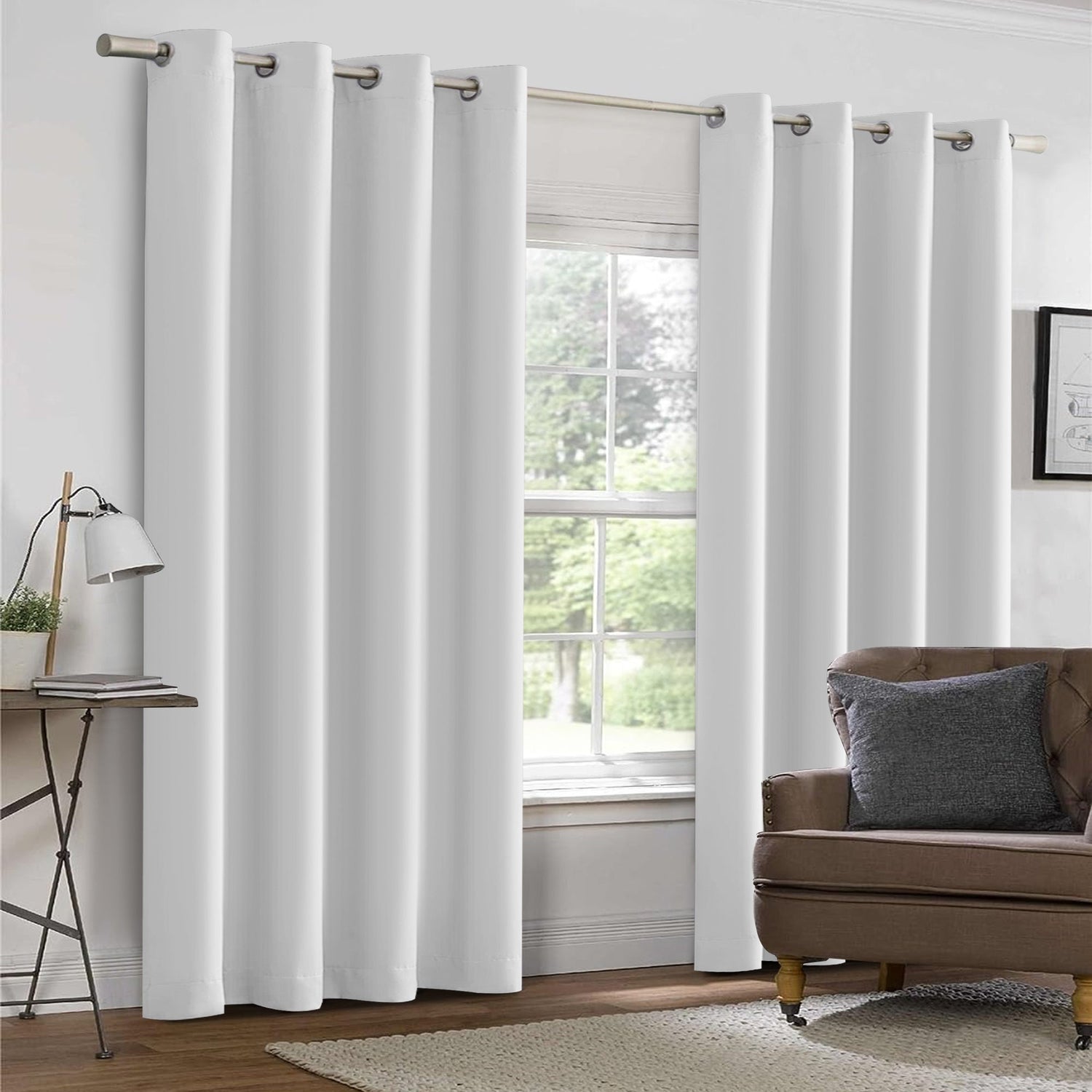 White curtains in a living room with a brown sofa and lamp.