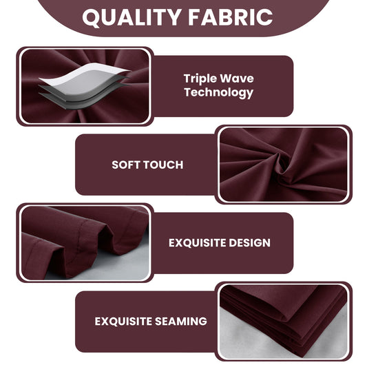Maroon curtains with grommets on a window, with a plant and table in the foreground.
