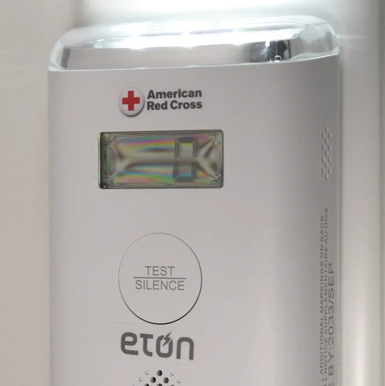 American Red Cross and Eton device with a test and silence button on a white background