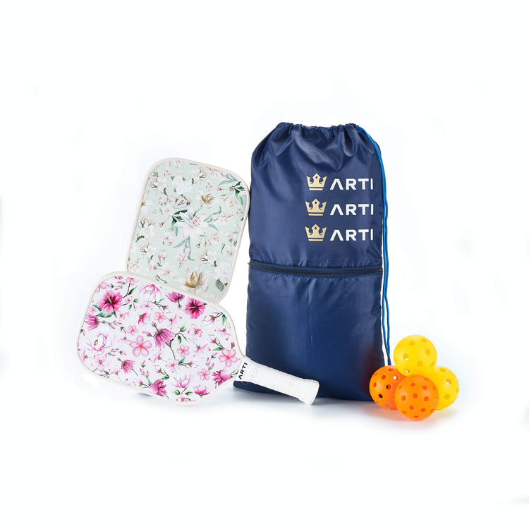 Floral-patterned pickleball paddles with a blue drawstring bag and colorful balls on a white background