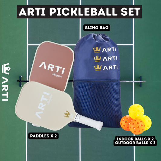 Two paddle tennis rackets and three balls with a blue drawstring bag on a white background