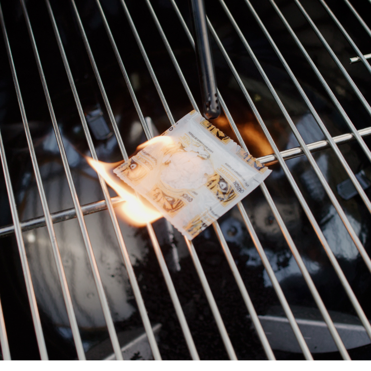 Currency note on a grill with flames