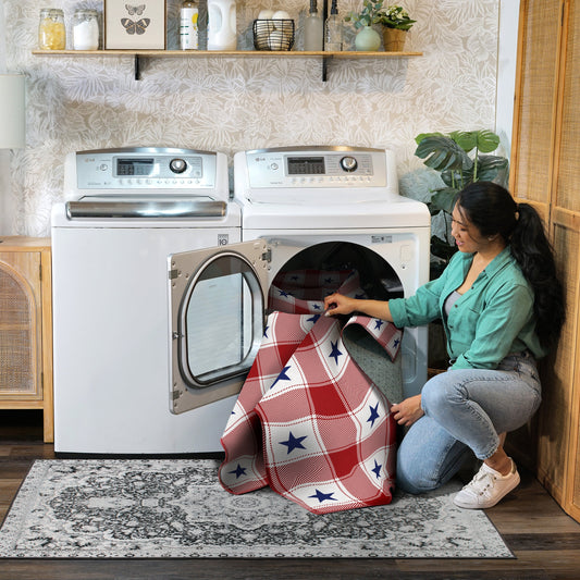 Wooden bench with American flag pillow and plaid rug on wooden floor