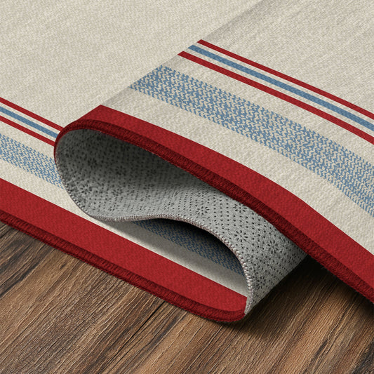 Wooden bench with striped cushions in a room with a red and white patterned rug.