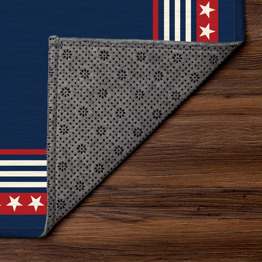 Navy blue rug with red and white border in front of a wooden bench and American flag.