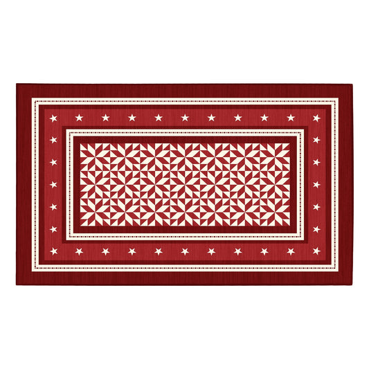 Decorative red and white patterned rug on a wooden floor in a kitchen.