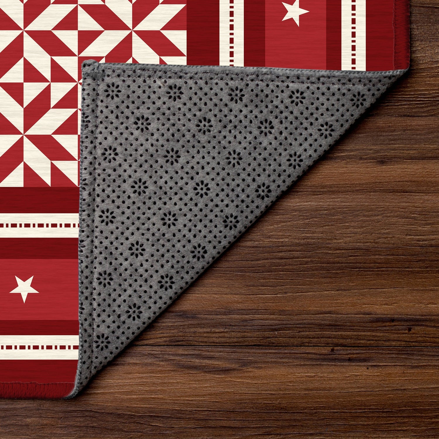 Gray patterned fabric on a wooden surface with a red and white quilted background