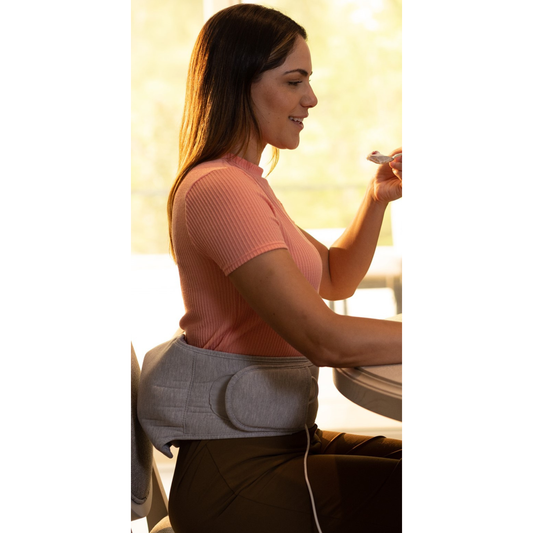Sharper Image Calming Heat Back Wrap packaging with a person wearing the wrap on a white background