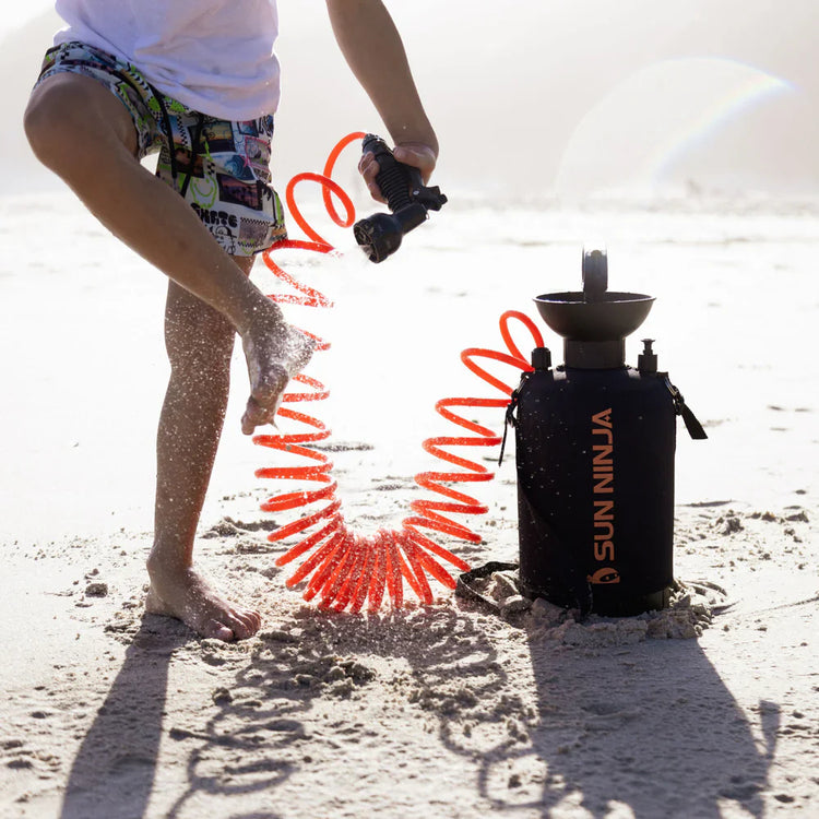 Person using a Sun Ninja product on a sandy surface