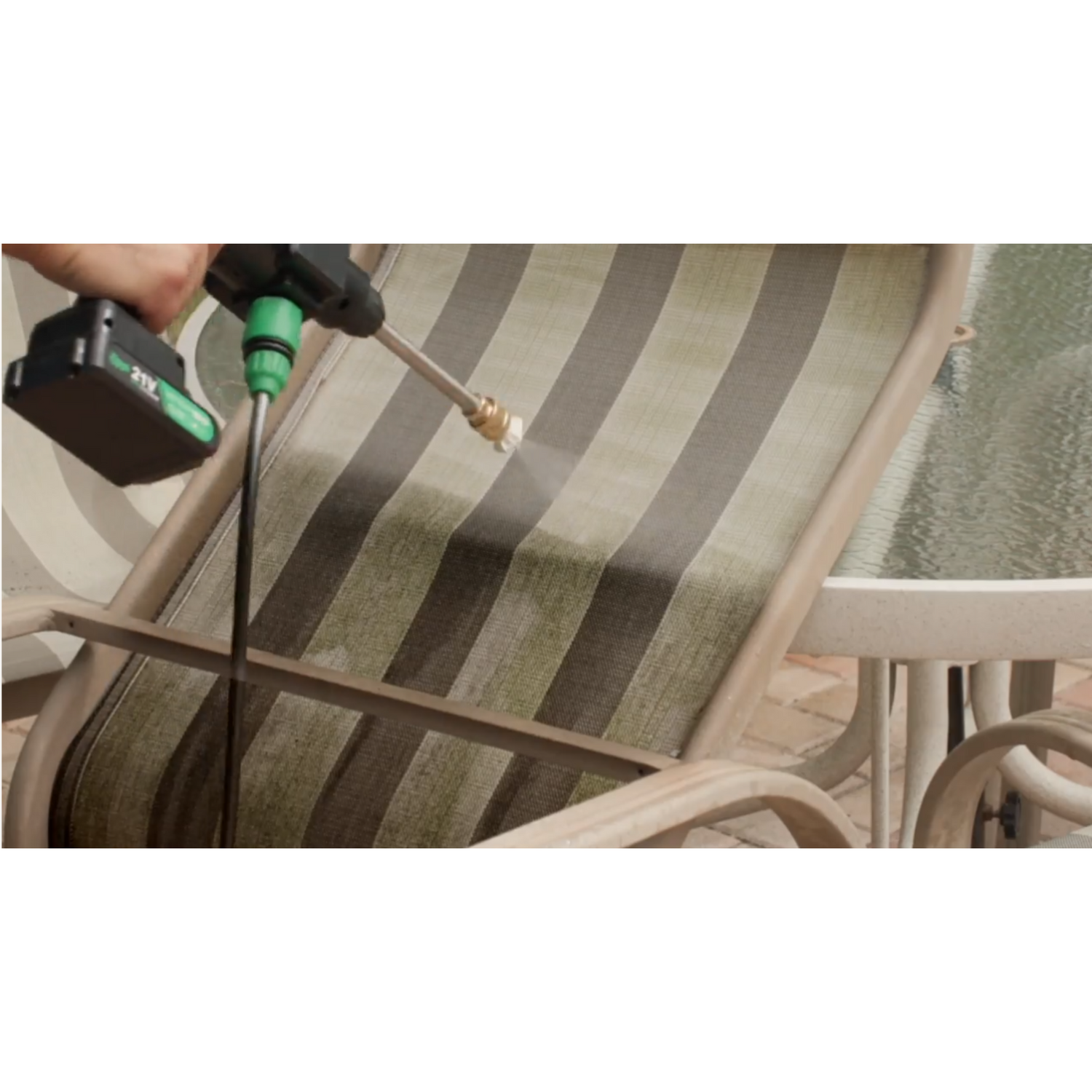 Person cleaning a patio chair with a pressure washer.