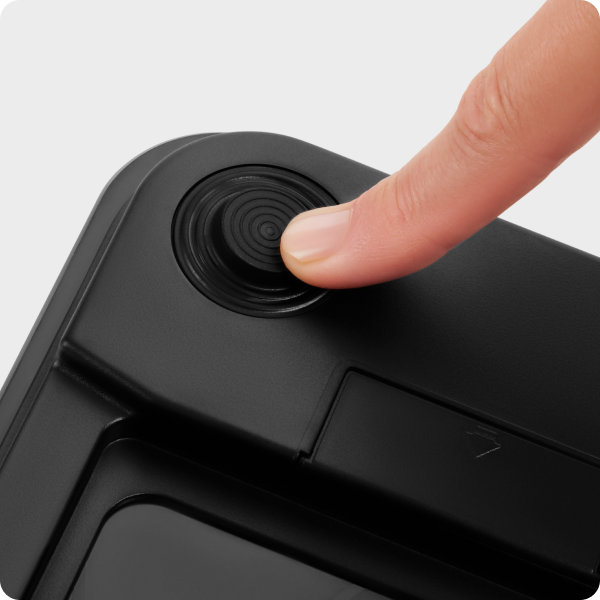 Black electronic device with a finger pressing a button on a white background