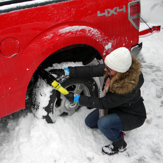 Two tires with snow chains and a green carrying bag on a white background