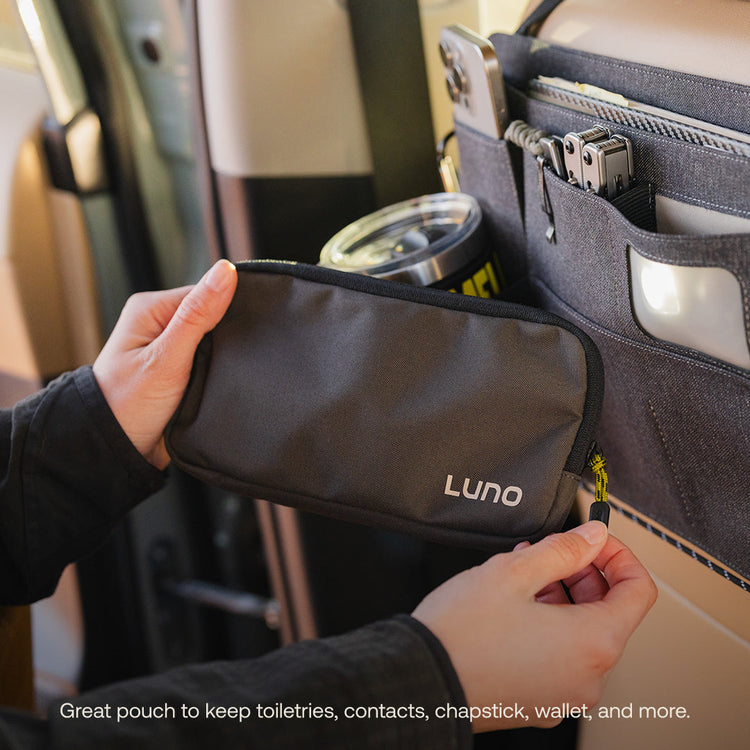 Hands holding a dark zippered pouch labeled "Luno®" near a Seatback Organizer, which stores items like a phone and tumbler. Text reads, "Ideal pouch for toiletries, contacts, chapstick, wallet—perfect for easy car camping organization.