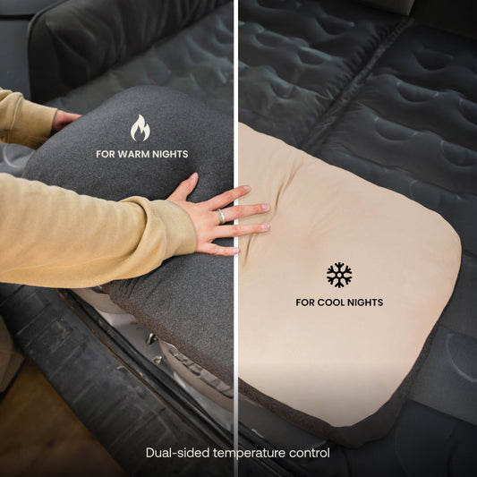 A car’s back seat is converted into a sleeping area with a gray inflatable mattress and Luno® Packable Camping Pillow. The mattress features “DRIVE. CAMP. EXPLORE.”.