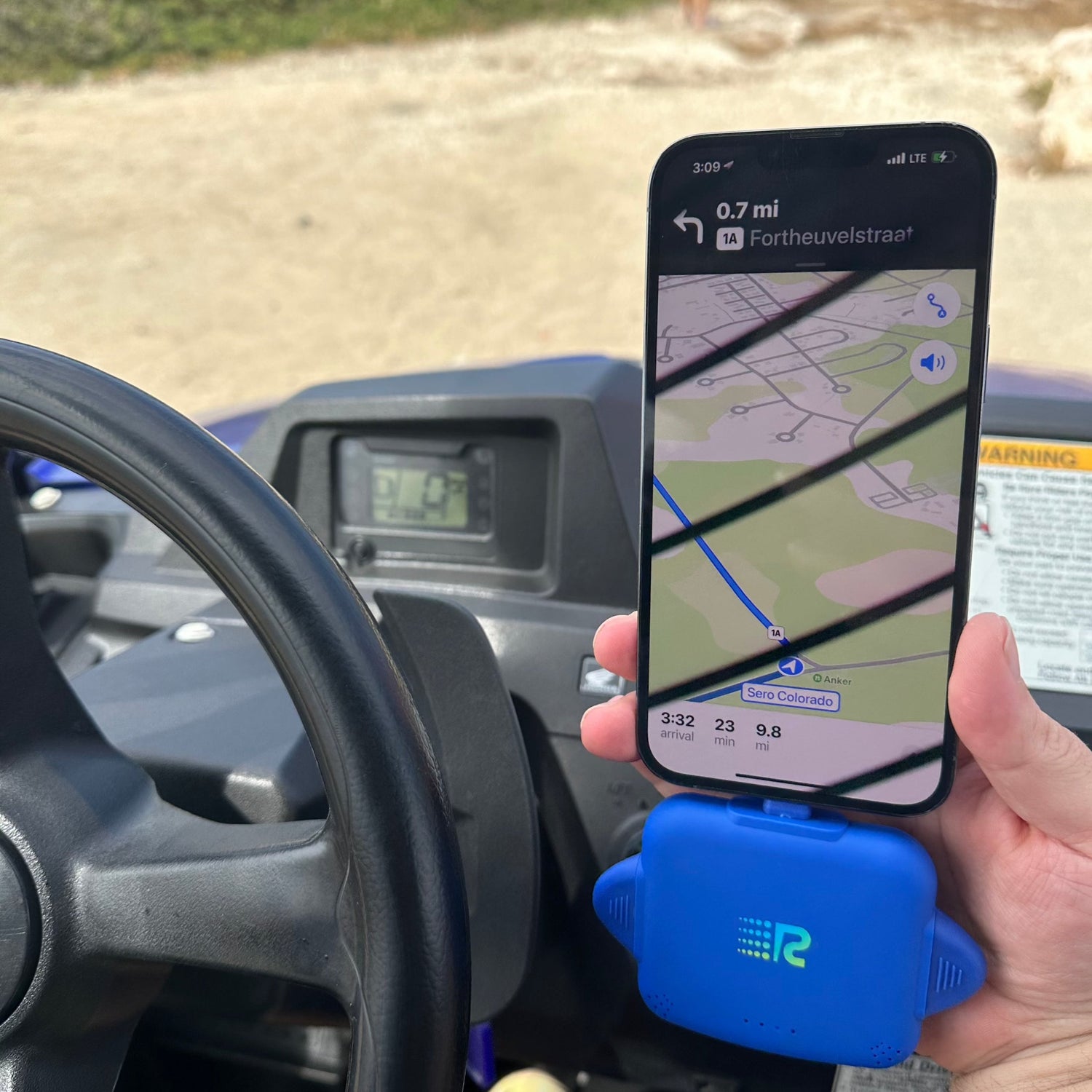 Person holding a phone with GPS app on a car dashboard