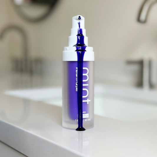 A product image showing a box and tube of Mint InstantPurple Color Corrector with nHAp. The packaging is primarily purple and white with text detailing the product's benefits and instructions for use.