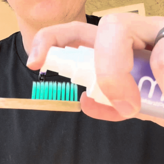 A product image showing a box and tube of Mint InstantPurple Color Corrector with nHAp. The packaging is primarily purple and white with text detailing the product's benefits and instructions for use.