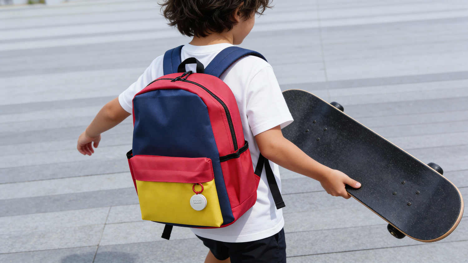 Child with a colorful backpack and skateboard on a pavement