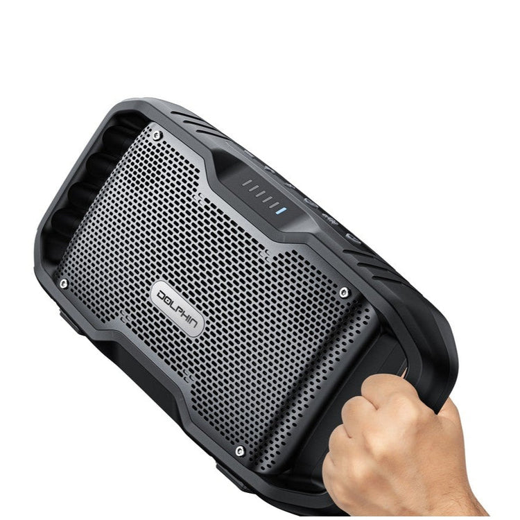 Black portable speaker held by a hand on a white background