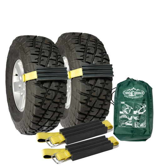 Two tires with snow chains and a green carrying bag on a white background