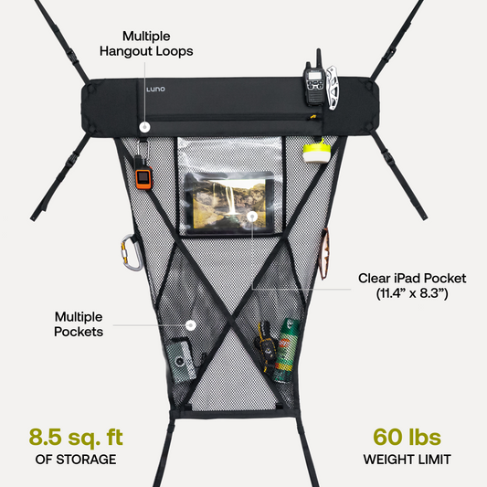 Interior view of an adventure mobile showcasing a Luno® Cargo Hammock attached to the ceiling above the back seats. Various items such as tools and small bags are stored on the portable gear shelf, maximizing storage space. The rear seats and part of the front seats are visible.
