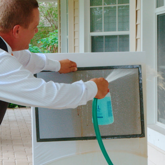 Person using a hose to clean the exterior of a house