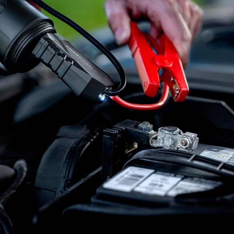 Car jump starter being used to charge a car battery