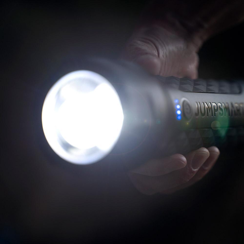 Hand holding a flashlight with 'Jumper' branding in a dark setting
