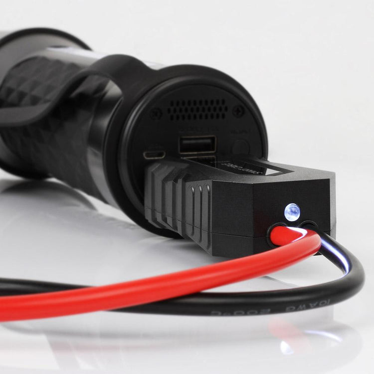 Close-up of a black electrical connector with red and black wires on a white background
