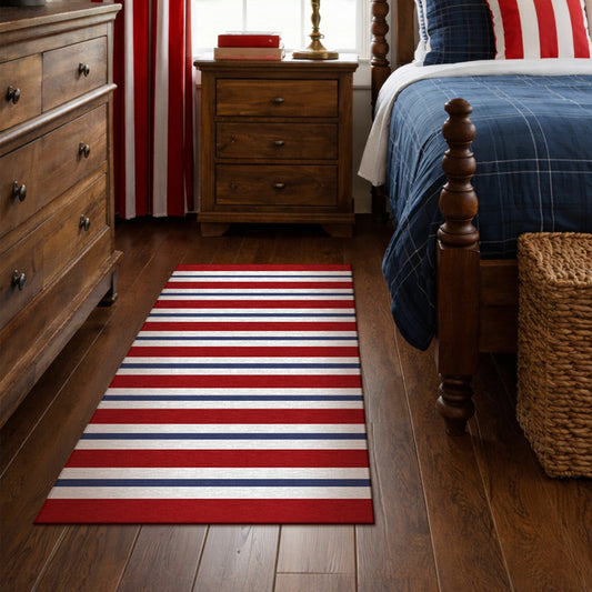 Wooden bench with decorative pillows on a porch featuring a red, white, and blue striped rug.