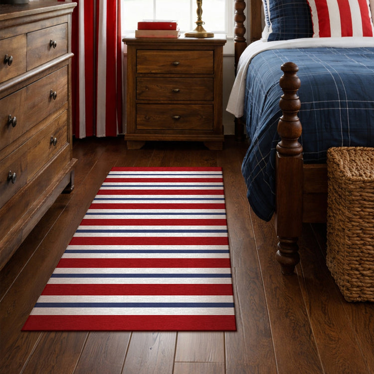Bedroom with a red, white, and blue striped rug on wooden flooring.