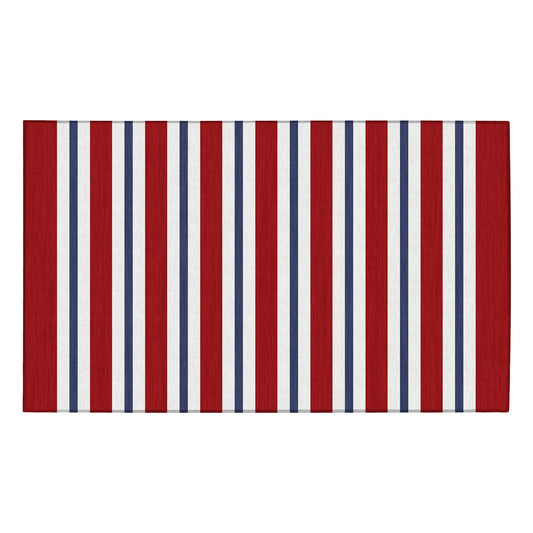Wooden bench with decorative pillows on a porch featuring a red, white, and blue striped rug.