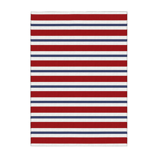 Wooden bench with decorative pillows on a porch featuring a red, white, and blue striped rug.