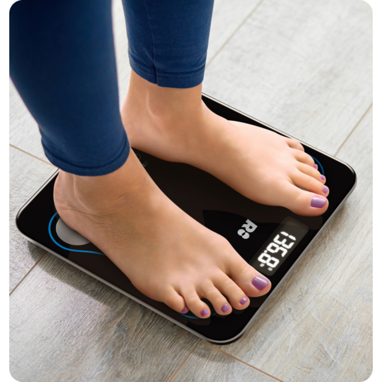 Person standing on a digital scale with a white floor background